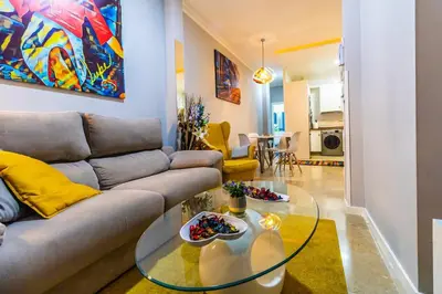 a living room with a couch and a glass table at SH Lupe Caleta Beach. A 100 m de playa in Cádiz