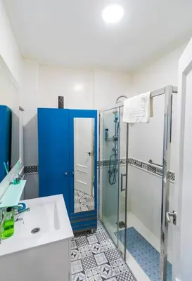 a bathroom with a shower and a blue door at SH Lupe Caleta Beach. A 100 m de playa in Cádiz