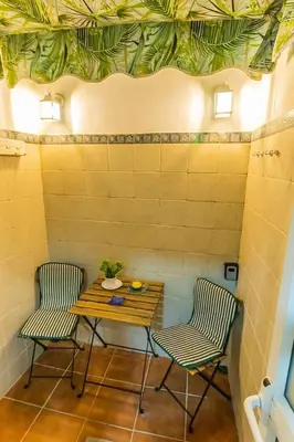 two chairs and a table in a room with a table and two chairs at SH Lupe Caleta Beach. A 100 m de playa in Cádiz