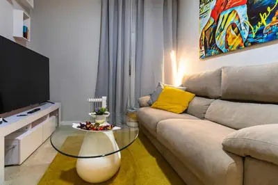a living room with a couch and a glass table at SH Lupe Caleta Beach. A 100 m de playa in Cádiz