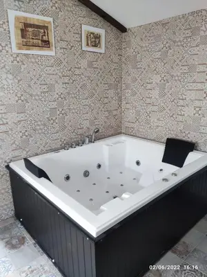 a bath tub in a bathroom with a wall at Villa egipto con jacuzzi y piscina climatizada in Chiclana de la Frontera