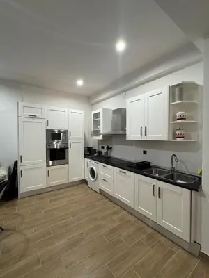 a kitchen with white cabinets and a sink and a dishwasher at Terra Centro Cádiz in Cádiz