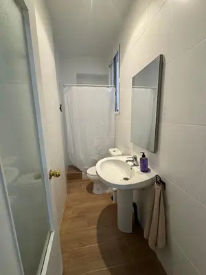 a bathroom with a sink and a toilet and a mirror at Terra Centro Cádiz in Cádiz