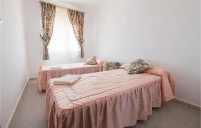 a bedroom with two beds and a window at 6 Bedroom Gorgeous Home In Chipiona in Chipiona