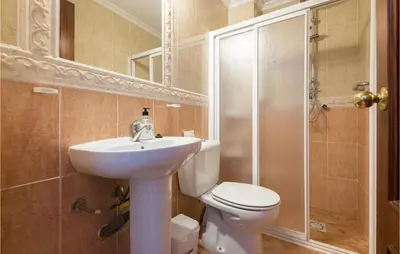 a bathroom with a toilet and a sink and a shower at 6 Bedroom Gorgeous Home In Chipiona in Chipiona