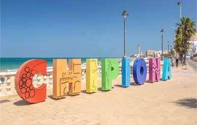 a row of colorful signs on the beach at 6 Bedroom Gorgeous Home In Chipiona in Chipiona