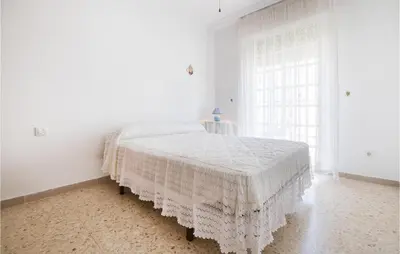 a white bedroom with a bed with a white bedspread at 6 Bedroom Gorgeous Home In Chipiona in Chipiona
