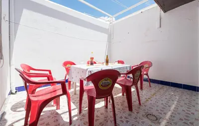 a dining room with a table and red chairs at 6 Bedroom Gorgeous Home In Chipiona in Chipiona