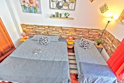 a bedroom with two beds and a brick wall at Ribera De Luxe Central Apartment with Ascensor in El Puerto de Santa María