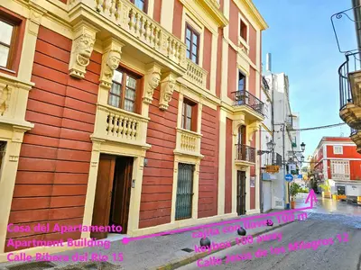a red and yellow building with a sign in front of it at Ribera De Luxe Central Apartment with Ascensor in El Puerto de Santa María