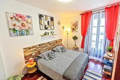 a bedroom with a bed and red curtains at Ribera De Luxe Central Apartment with Ascensor in El Puerto de Santa María