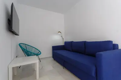 a living room with a blue couch and a chair at Atico del Buen CANTAOR by Cadiz4Rentals in Cádiz