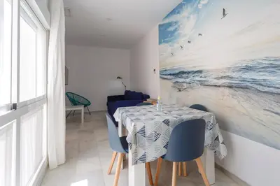 a dining room with a table and blue chairs at Atico del Buen CANTAOR by Cadiz4Rentals in Cádiz