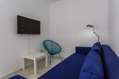 a living room with a blue couch and a chair at Atico del Buen CANTAOR by Cadiz4Rentals in Cádiz