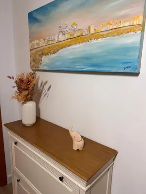 a painting on a wall next to a dresser at Apartamento Playa Victoria in Cádiz