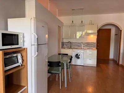 a kitchen with a table with chairs and a microwave at Apartamento Playa Victoria in Cádiz