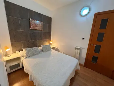 a bedroom with a bed and a desk and a door at Apartamento Playa Victoria in Cádiz