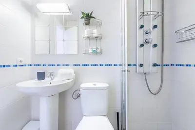 a bathroom with a toilet and a sink and a shower at Jerez Paralejo Ha Apartment in Jerez de la Frontera