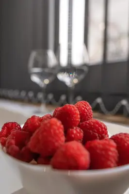 a white bowl of raspberries on a table at Mina50 by 7Escalones in Rota