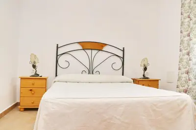 a bedroom with a white bed and two night stands at Chalet Florida II in Conil de la Frontera