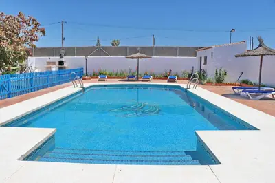 a large swimming pool with blue water at Chalet Florida II in Conil de la Frontera