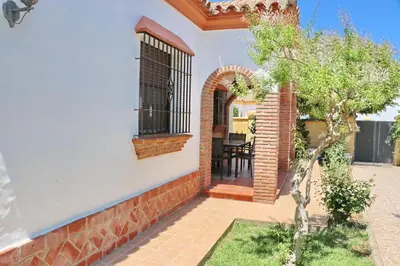 a home with an arched window and a patio at Chalet Florida II in Conil de la Frontera