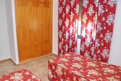 a room with red curtains and a wooden door at Chalet Florida IV in Conil de la Frontera