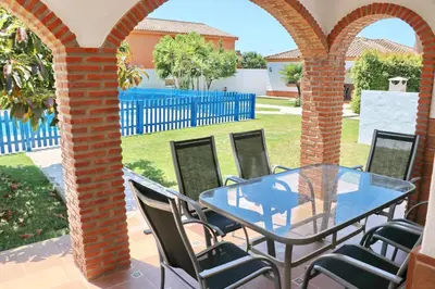 a patio with a glass table and chairs at Chalet Florida IV in Conil de la Frontera