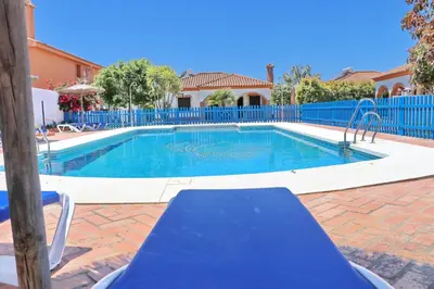 a swimming pool with a blue fence around it at Chalet Florida IV in Conil de la Frontera