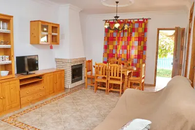a living room with a table and a dining room at Chalet Florida IV in Conil de la Frontera