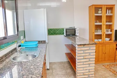 a kitchen with a sink and a tv on a counter at Chalet Florida IV in Conil de la Frontera