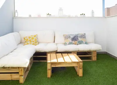 a living room with a white couch and two tables at El ático de Reyes in Sanlúcar de Barrameda
