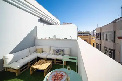a balcony with a couch and a table at El ático de Reyes in Sanlúcar de Barrameda