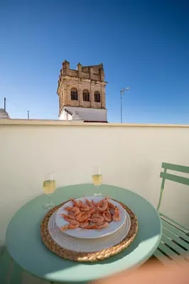 a plate of food on a table with two glasses of wine at El ático de Reyes in Sanlúcar de Barrameda