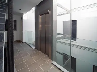 a hallway with glass doors and a tile floor at El ático de Reyes in Sanlúcar de Barrameda