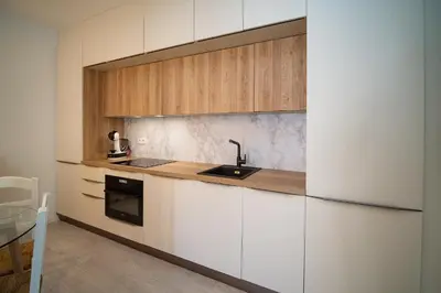 a kitchen with white cabinets and a sink at El ático de Reyes in Sanlúcar de Barrameda