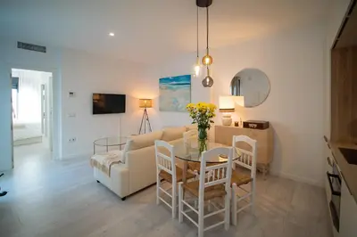 a living room with a table and a couch at El ático de Reyes in Sanlúcar de Barrameda