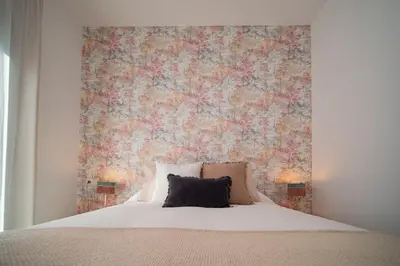a bedroom with a bed with a floral wall at El ático de Reyes in Sanlúcar de Barrameda