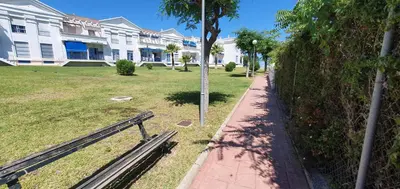 a park with a bench in front of a building at Apartamento turístico la jara in Sanlúcar de Barrameda