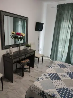 a bedroom with a desk with a mirror and a bed at Apartamento turístico la jara in Sanlúcar de Barrameda
