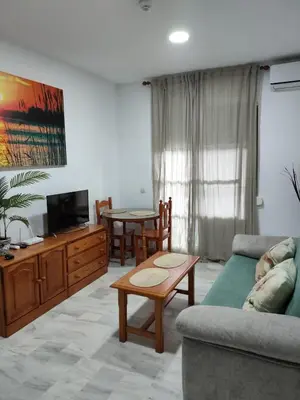 a living room with a couch and a table at Apartamento turístico la jara in Sanlúcar de Barrameda