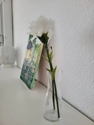 a white flower in a glass vase on a table at La Costilla centro y playa in Rota