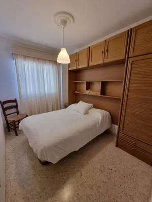 a bedroom with a large white bed and a chair at Gallegos House in Lebrija