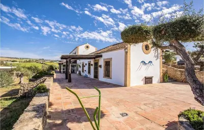 an exterior view of a house with a tree at Amazing Home In Arcos De La Frontera in Arcos de la Frontera