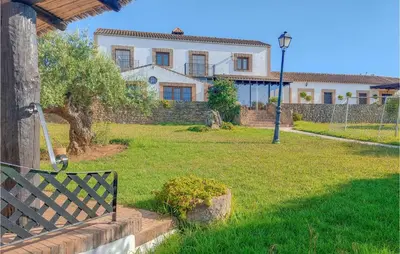 a house with a fence and a bench in a yard at Amazing Home In Arcos De La Frontera in Arcos de la Frontera