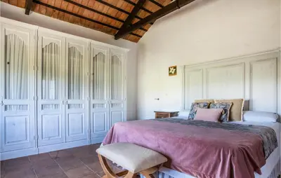 a bedroom with a large bed and a chair at Amazing Home In Arcos De La Frontera in Arcos de la Frontera