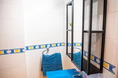a bathroom with a blue sink and a mirror at Apartamento AGUAMAR in Sanlúcar de Barrameda