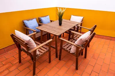 a wooden table and chairs with a vase on it at Apartamento AGUAMAR in Sanlúcar de Barrameda