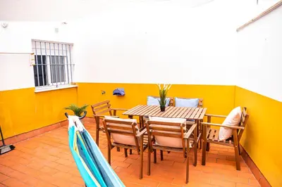 a dining room with a wooden table and chairs at Apartamento AGUAMAR in Sanlúcar de Barrameda