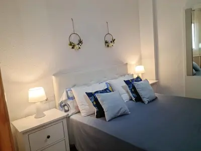 a bedroom with a bed with blue and white pillows at Apartamento centro Rota. 2 minutos de la playa.. in Rota